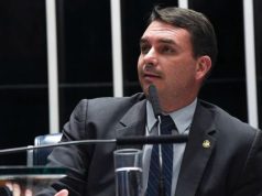 senador Flávio Bolsonaro (PL-RJ) olhando para o lado, sério, falando