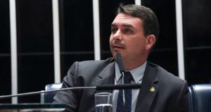senador Flávio Bolsonaro (PL-RJ) olhando para o lado, sério, falando