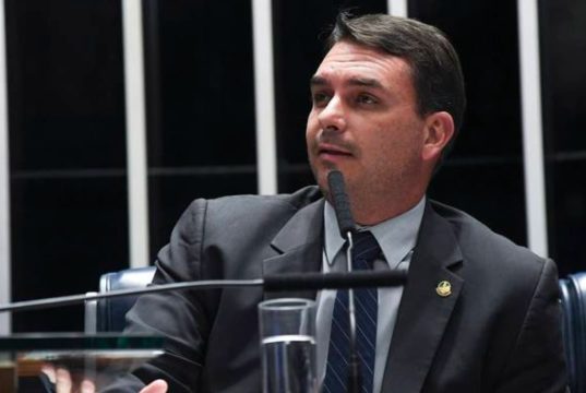 senador Flávio Bolsonaro (PL-RJ) olhando para o lado, sério, falando
