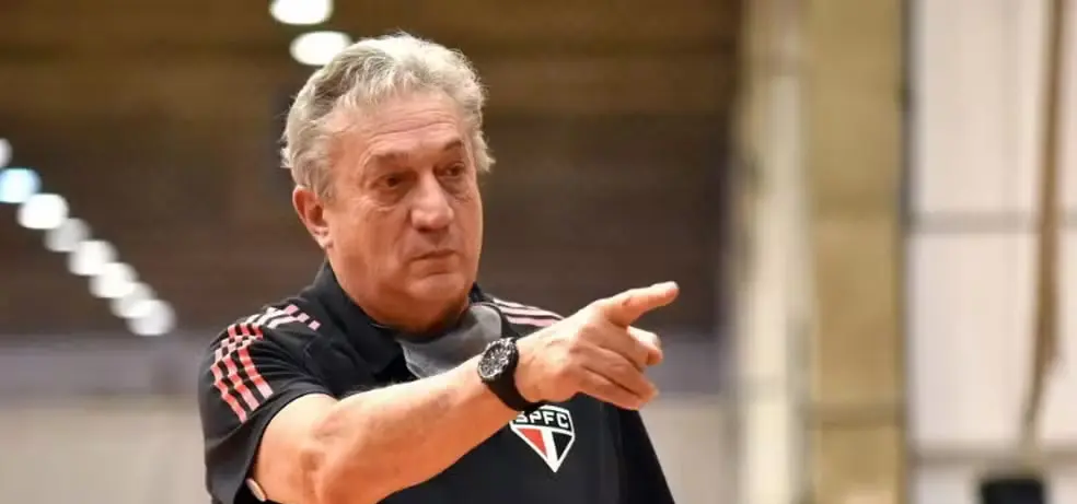 Cláudio Mortari, ex-técnico da seleção brasileira de basquete, sério, apontando pra frente sem olhar para a câmera, com camisa do SPFC
