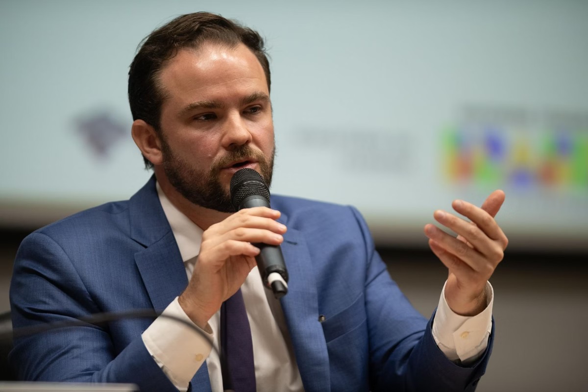 secretário-executivo Dario Durigan falando em microfone, sério, gesticulando