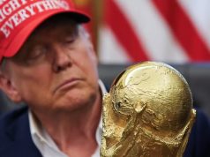 Donald Trump, presidente dos Estados Unidos, de boné, sério, olhando para taça