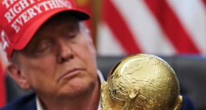 Donald Trump, presidente dos Estados Unidos, de boné, sério, olhando para taça