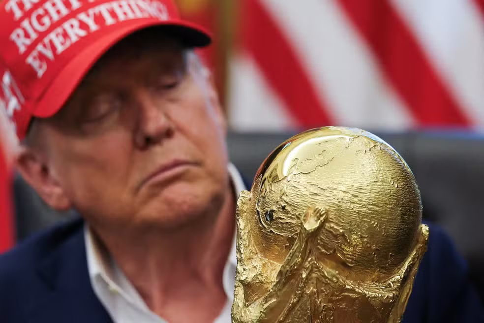 Donald Trump, presidente dos Estados Unidos, de boné, sério, olhando para taça