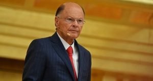 Edir Macedo sério, de roupa social e óculos de grau, sem olhar para a câmera