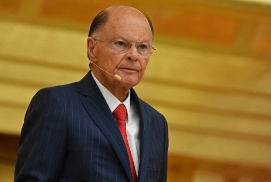 Edir Macedo sério, de roupa social e óculos de grau, sem olhar para a câmera