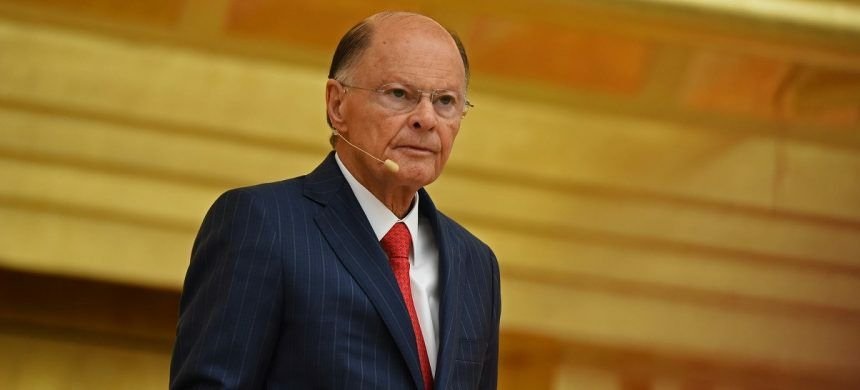 Edir Macedo sério, de roupa social e óculos de grau, sem olhar para a câmera