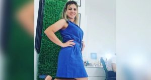 Roberta Jersyka Oliveira Brasil Soares, ex-aluna de medicina da USP, sorrindo, de vestido azul, mostrando tornozeleira eletrônica