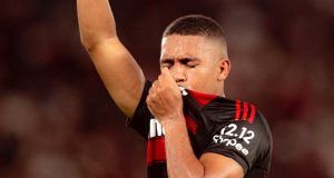 Samuel Lino beijando a camisa do Flamengo de olhos fechados e apontando pra cima
