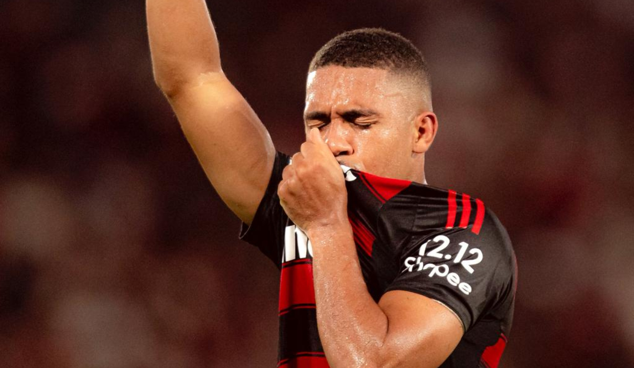 Samuel Lino beijando a camisa do Flamengo de olhos fechados e apontando pra cima