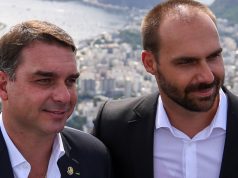 O senador Flávio Bolsonaro (PL-RJ) e o ex-deputado federal Eduardo Bolsonaro (PL-SP) em close, lado a lado, sem olhar para a câmera
