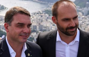 O senador Flávio Bolsonaro (PL-RJ) e o ex-deputado federal Eduardo Bolsonaro (PL-SP) em close, lado a lado, sem olhar para a câmera