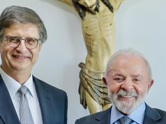 Paulo Gonet e o presidente Lula (PT) sorrindo lado a lado e olhando para a câmera