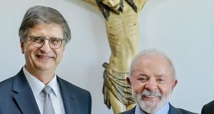 Paulo Gonet e o presidente Lula (PT) sorrindo lado a lado e olhando para a câmera