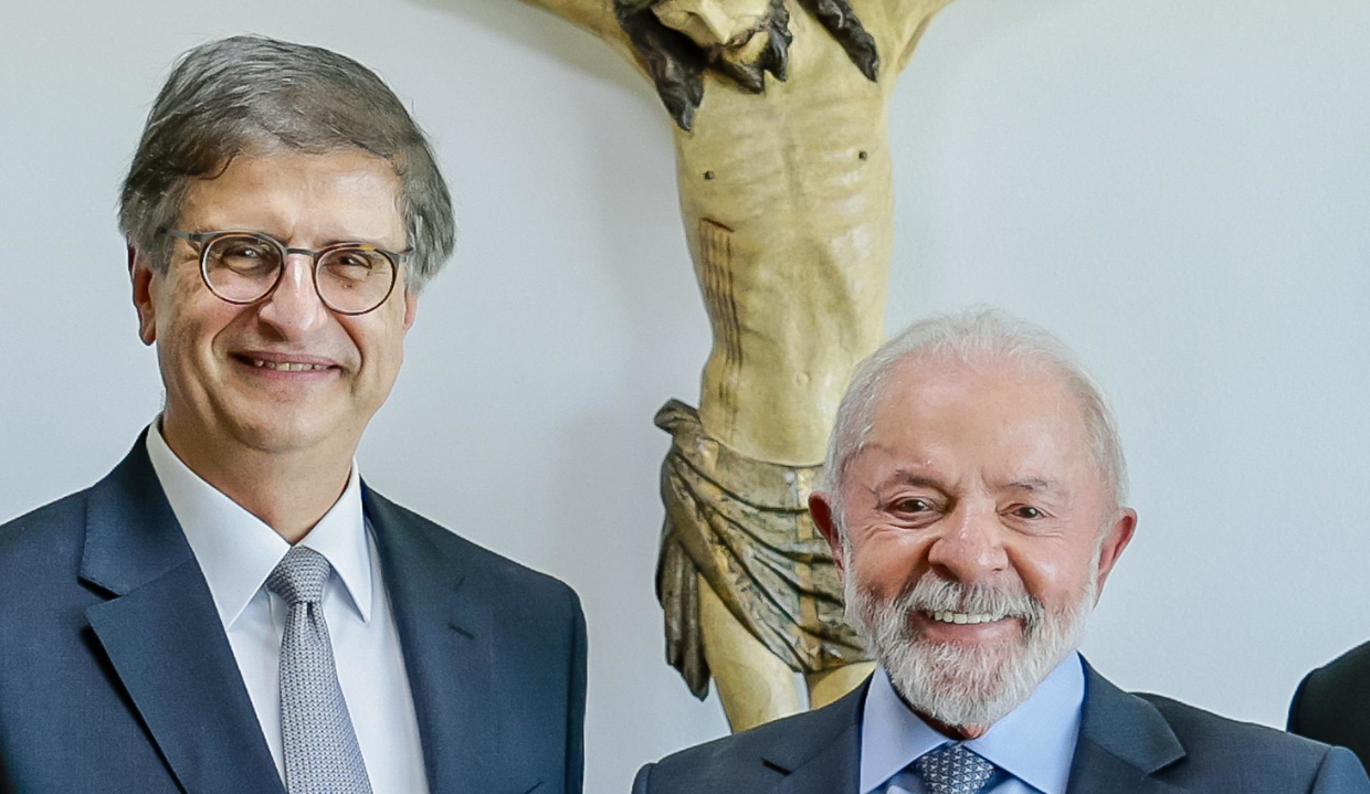 Paulo Gonet e o presidente Lula (PT) sorrindo lado a lado e olhando para a câmera