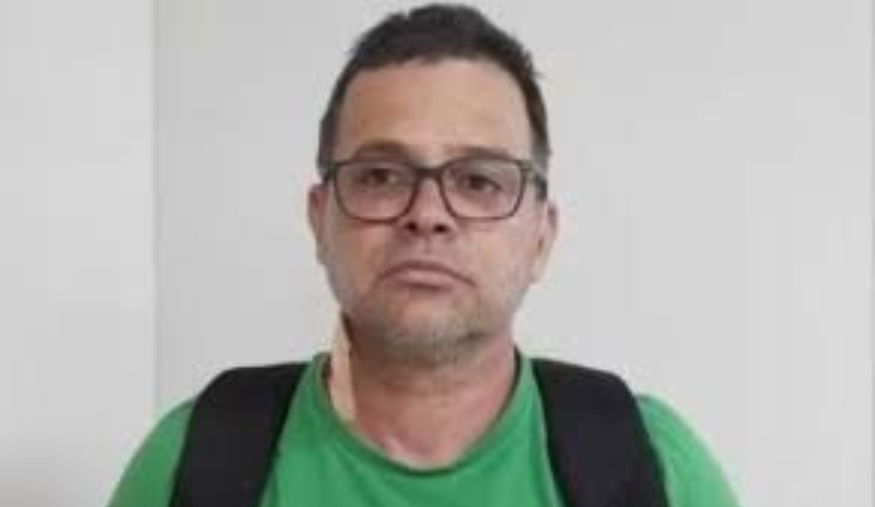 ex-diretor-geral da PRF (Polícia Rodoviária Federal) Silvinei Vasques de camiseta verde, óculos e mochila preta nas costas, olhando para a câmera, sério