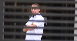 Ex-presidente Jair Bolsonaro em prisão domiciliar, de camisa branca e braços cruzados