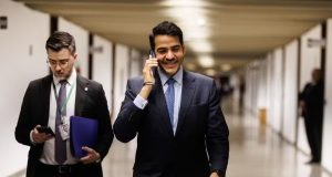 Jorge Messias circulando pelo Senado, andando, sorrindo e falando ao telefone