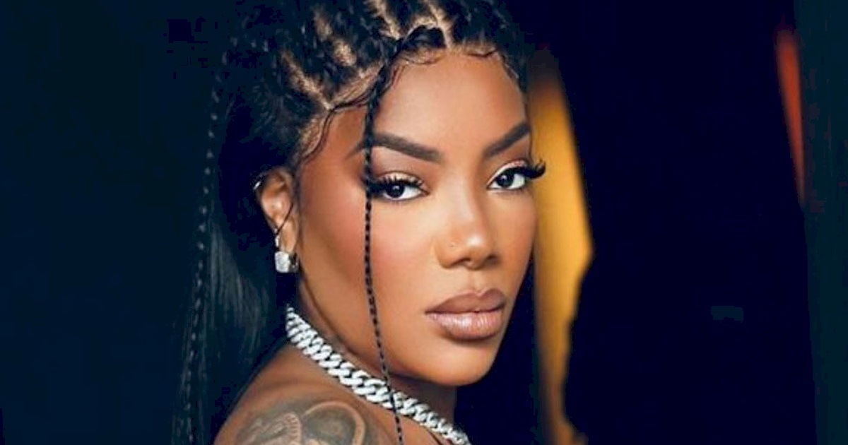 Ludmilla em close, olhando para a câmera, séria