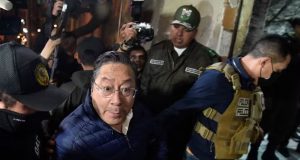 Luis Arce, ex-presidente da Bolívia, sendo escoltado por policiais após audiência