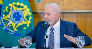 O presidente Luiz Inácio Lula da Silva (PT) sentado, olhando para o lado, falando e gesticulando, sério