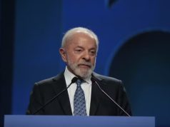 O presidente Luiz Inácio Lula da Silva (PT) falando em microfone, sério