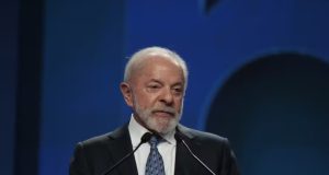 O presidente Luiz Inácio Lula da Silva (PT) falando em microfone, sério