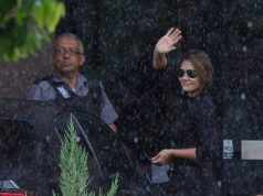 A ex-primeira-dama Michelle Bolsonaro (PL-DF) acenando, de roupa preta e óculos escuros