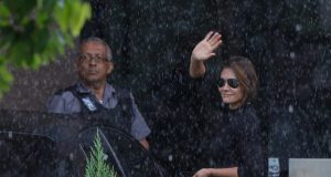 A ex-primeira-dama Michelle Bolsonaro (PL-DF) acenando, de roupa preta e óculos escuros