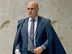 ministro Alexandre de Moraes andando, sério, em pé, olhando para o lado