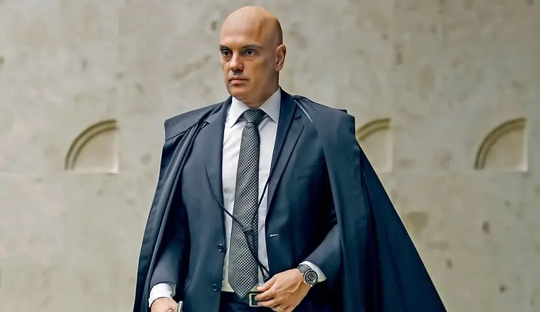 ministro Alexandre de Moraes andando, sério, em pé, olhando para o lado