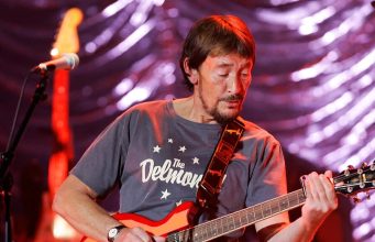 O cantor britânico Chris Rea cantando e tocando durante show