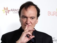 O cineasta Quentin Tarantino, com expressão pensativa e dedo na boca