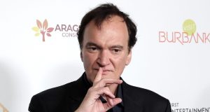 O cineasta Quentin Tarantino, com expressão pensativa e dedo na boca
