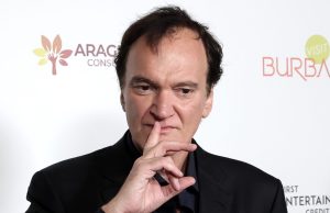 O cineasta Quentin Tarantino, com expressão pensativa e dedo na boca