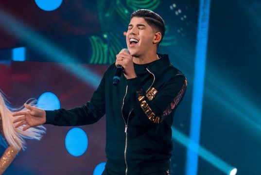 cantor Zé Vaqueiro cantando, de olhos fechados, segurando microfone