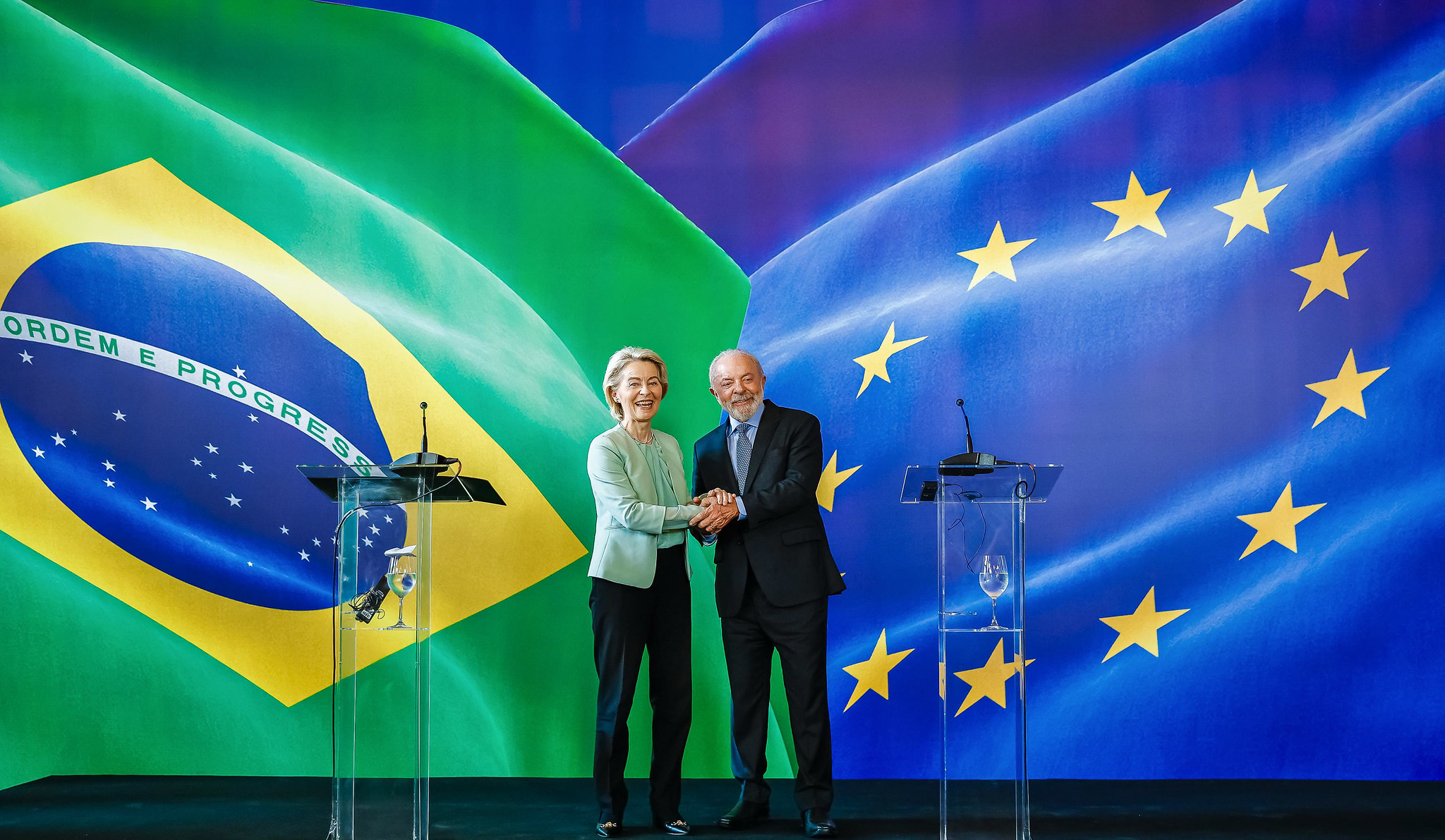 presidente da Comissão Europeia, Ursula von der Leyen, ao lado do presidente Luiz Inácio Lula da Silva (PT), os dois sorrindo e apertando as mãos um do outro