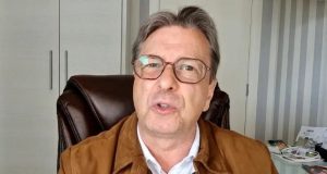 O deputado federal Bibo Nunes de óculos de grau e roupa de frio caramelo e branca falando para a câmera