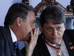 Jair Bolsonaro sentado ao lado de Tarcísio e cochichando no ouvido dele