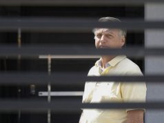 Jair Bolsonaro em prisão domiciliar, de camisa amarela, sério