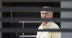 Jair Bolsonaro em prisão domiciliar, de camisa amarela, sério