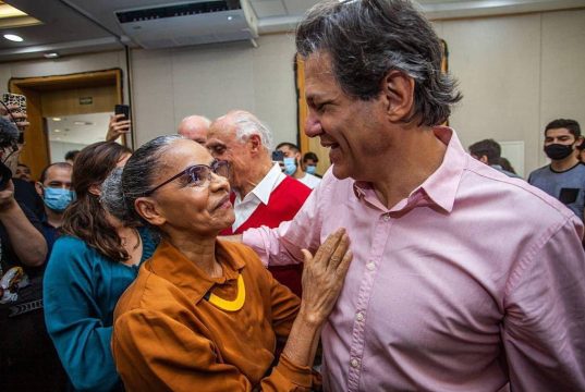 ministros Fernando Haddad, da Fazenda, e Marina Silva, se cumprimentando e sorrindo em abraço