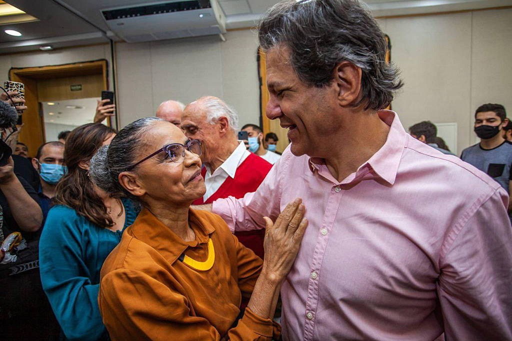 ministros Fernando Haddad, da Fazenda, e Marina Silva, se cumprimentando e sorrindo em abraço