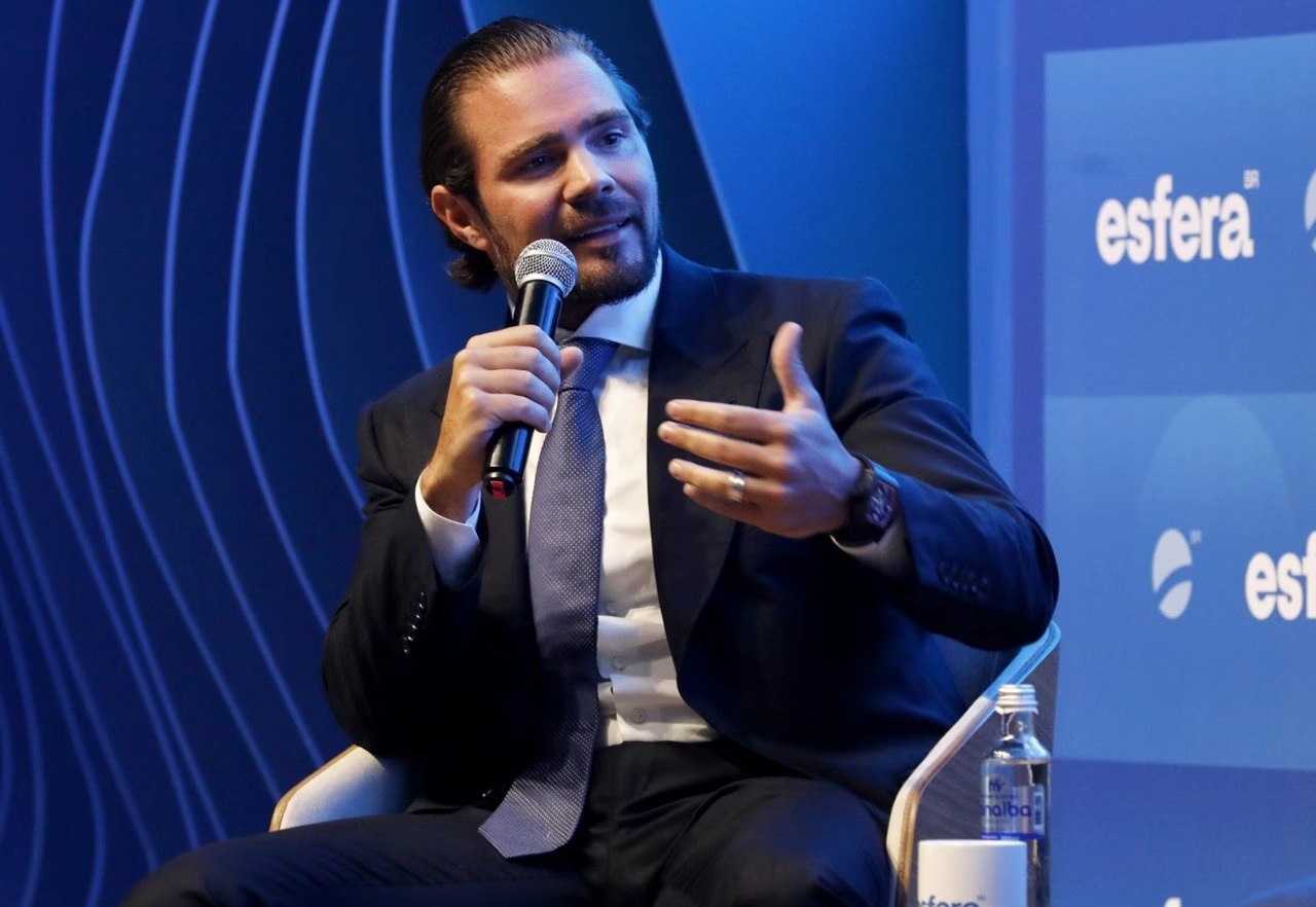 ex-banqueiro Daniel Vorcaro falando em microfone, olhando para o lado, sentado, gesticulando de roupa social escura