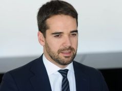 O governador do Rio Grande do Sul, Eduardo Leite, falando, sem olhar para a câmera, de roupa social, sério