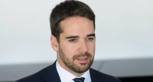 O governador do Rio Grande do Sul, Eduardo Leite, falando, sem olhar para a câmera, de roupa social, sério