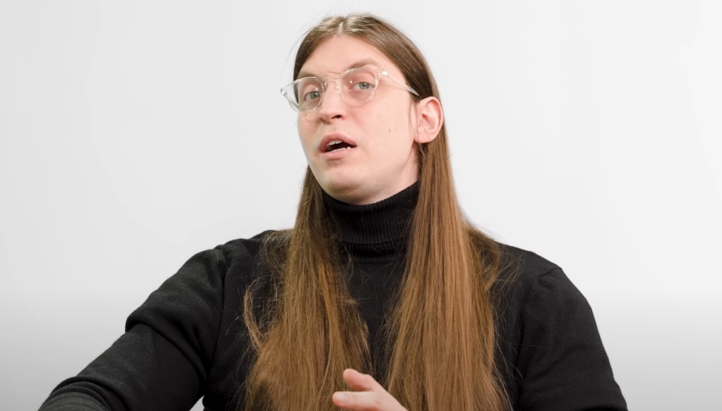 O influenciador digital Felipe Bressanim, conhecido como Felca, de roupa preta e cabelo solto, falando, de óculos de grau