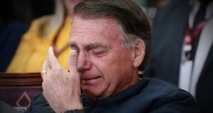 Jair Bolsonaro chorando com a mão no rosto