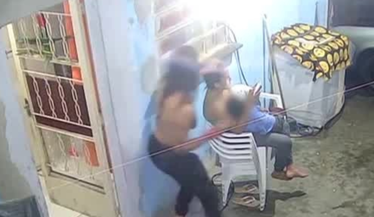 Mulher atacando mãe que está sentada com filho no colo