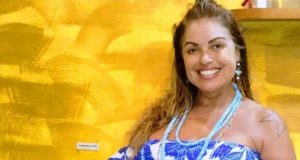 A turista Gisele Madrid Spencer Cesar de roupa azul e cabelo solto, sorrindo para a câmera